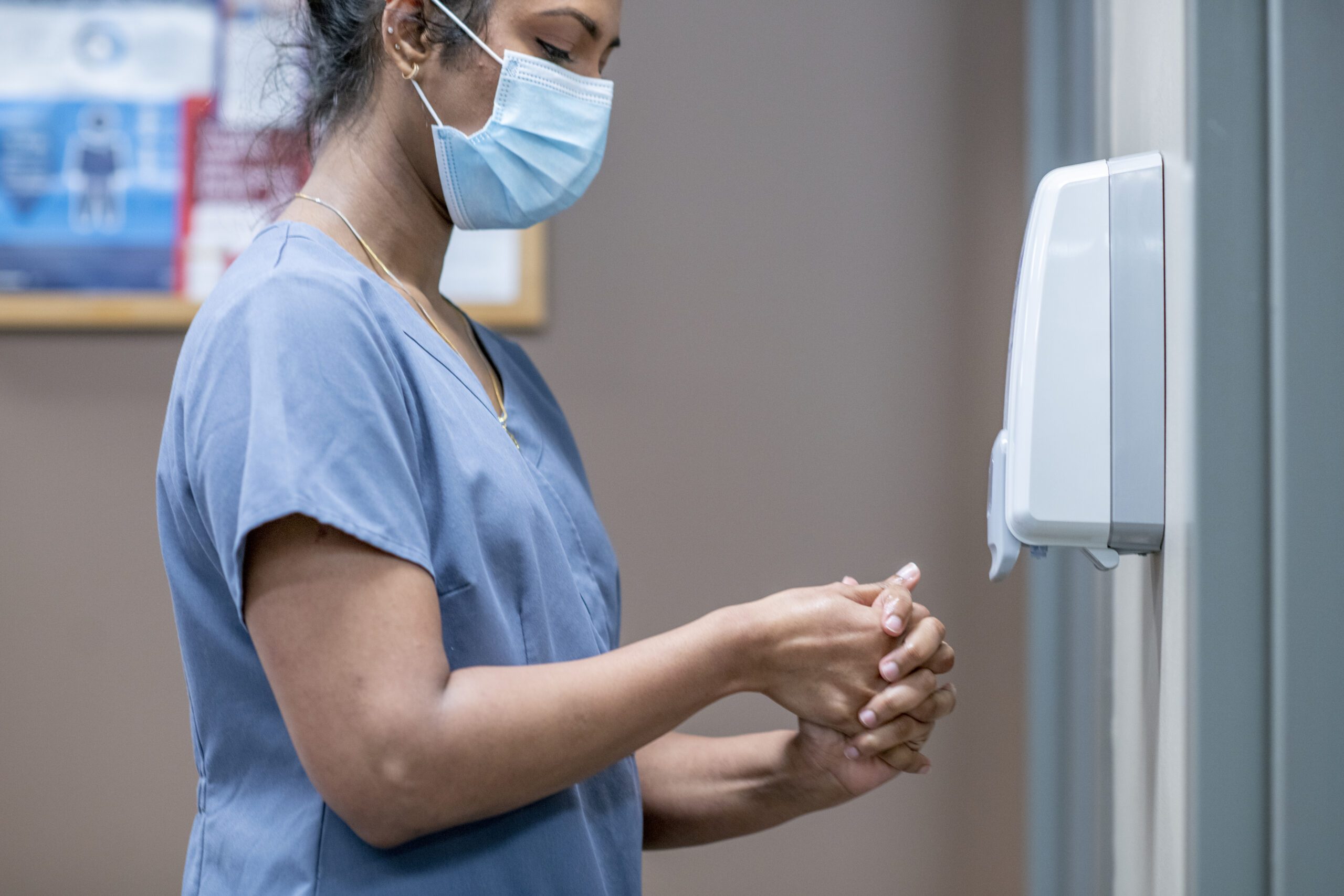 A healthcare professional using the proper hand sanitizer application technique.